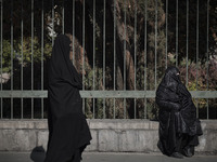 An Iranian veiled woman wearing a protective face mask walks along an avenue to the University of Tehran for taking part the Friday prayers...