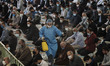 An Iranian man wearing protective suits sprays disinfectants to disinfect worshippers at t...