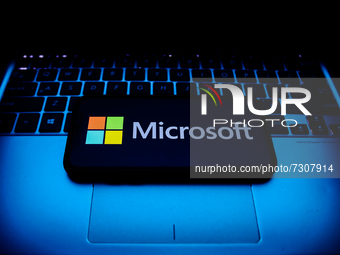 Microsoft logo displayed on a phone screen and a laptop keyboard are seen in this illustration photo taken in Krakow, Poland on October 30,...