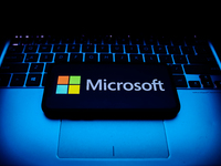 Microsoft logo displayed on a phone screen and a laptop keyboard are seen in this illustration photo taken in Krakow, Poland on October 30,...