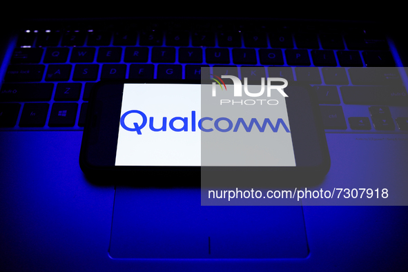 Qualcomm logo displayed on a phone screen and a laptop keyboard are seen in this illustration photo taken in Krakow, Poland on October 30, 2...