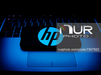 HP logo displayed on a phone screen and a laptop keyboard are seen in this illustration photo taken in Krakow, Poland on October 30, 2021. (