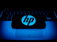 HP logo displayed on a phone screen and a laptop keyboard are seen in this illustration photo taken in Krakow, Poland on October 30, 2021. (