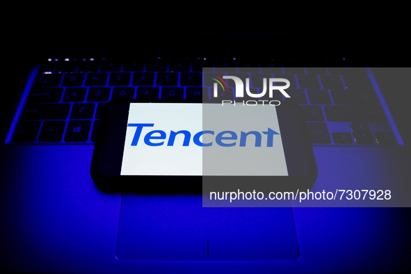 Tencent logo displayed on a phone screen and a laptop keyboard are seen in this illustration photo taken in Krakow, Poland on October 30, 20...