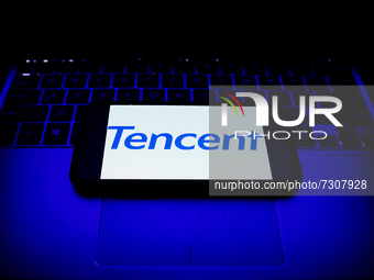 Tencent logo displayed on a phone screen and a laptop keyboard are seen in this illustration photo taken in Krakow, Poland on October 30, 20...