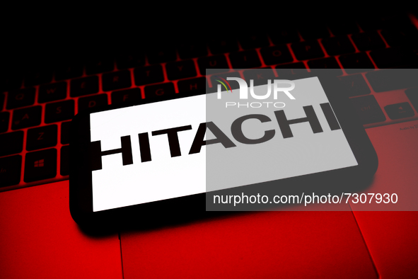 Hitachi logo displayed on a phone screen and a laptop keyboard are seen in this illustration photo taken in Krakow, Poland on October 30, 20...
