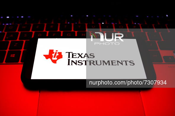 Texas Instruments logo displayed on a phone screen and a laptop keyboard are seen in this illustration photo taken in Krakow, Poland on Octo...