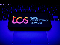Tata Consultancy Services logo displayed on a phone screen and a laptop keyboard are seen in this illustration photo taken in Krakow, Poland...