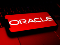 Oracle logo displayed on a phone screen and a laptop keyboard are seen in this illustration photo taken in Krakow, Poland on October 30, 202...