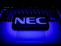 NEC logo displayed on a phone screen and a laptop keyboard are seen in this illustration photo taken in Krakow, Poland on October 30, 2021....