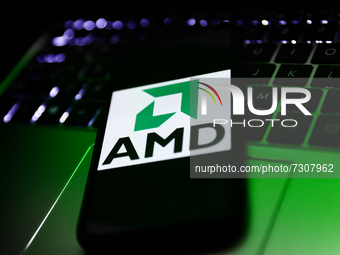 AMD logo displayed on a phone screen and a laptop keyboard are seen in this illustration photo taken in Krakow, Poland on October 30, 2021....