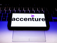 Accenture logo displayed on a phone screen and a laptop keyboard are seen in this illustration photo taken in Krakow, Poland on October 31,...