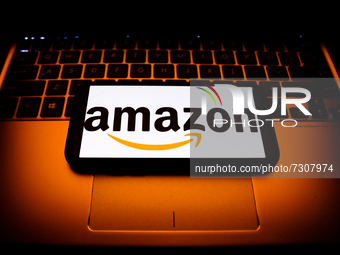 Amazon logo displayed on a phone screen and a laptop keyboard are seen in this illustration photo taken in Krakow, Poland on October 31, 202...