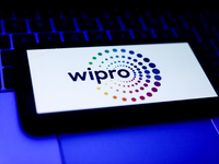 Wipro logo displayed on a phone screen and a laptop keyboard are seen in this illustration photo taken in Krakow, Poland on October 31, 2021...
