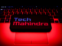 Tech Mahindra logo displayed on a phone screen and a laptop keyboard are seen in this illustration photo taken in Krakow, Poland on October...