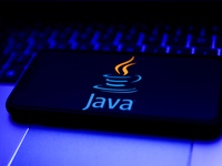 Java logo displayed on a phone screen and a laptop keyboard are seen in this illustration photo taken in Krakow, Poland on October 31, 2021....
