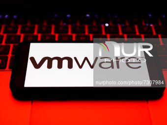 VMware logo displayed on a phone screen and a laptop keyboard are seen in this illustration photo taken in Krakow, Poland on October 31, 202...