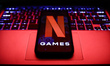 Netflix Games logo displayed on a phone screen and a laptop keyboard are seen in this illu...