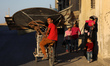A Palestinian man carries aluminum and iron on his bicycle at Deir al-Balah in central Gaz...