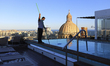A hotel worker cleans a rooftop pool in front of St. Paul's Cathedral in Valletta. Malta,...
