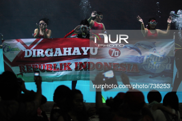 Some divers waving banners in order to celebrate the independence of the Republic of Indonesia in a giant aquarium, located in Jakarta, Mond...