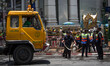 Workers clean up the debris from the explosion last night in Bangkok, front of the Erawan...