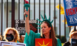 A demonstrator dressed as the Statue of Liberty awaits arrest during a civil disobedience...
