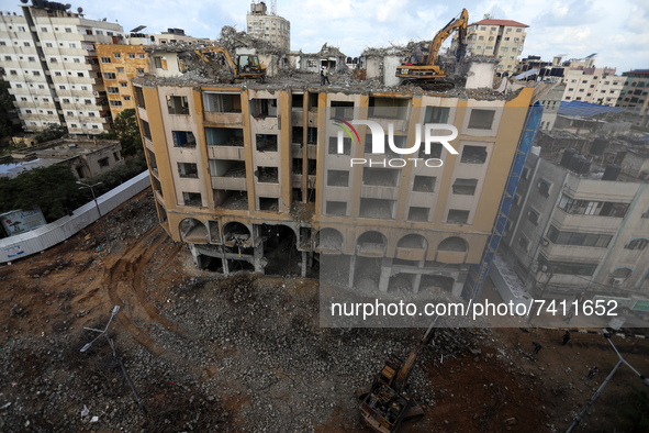  Palestinian workers clear the rubble of Al-Jawhara Tower building that was hit by Israeli air strikes during Israel-Palestinians fighting l...