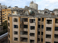  Palestinian workers clear the rubble of Al-Jawhara Tower building that was hit by Israeli air strikes during Israel-Palestinians fighting l...