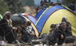 Migrants wait on the Macedonian-Greek border where they are being held, since Macedonia de...