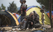 Migrants wait on the Macedonian-Greek border where they are being held, since Macedonia de...