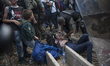 A young migrant woman faints after waiting on the Macedonian-Greek border where migrants a...