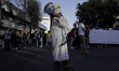 A chinela carries a girl before the First Great Parade of Huehuenches and Chinelos in Mexi...