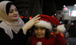 Palestinian Christians attend a Christmas tree lighting celebration in Gaza City, on Decem...
