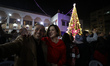 Palestinians take a selfie in front of a Christmas tree in Gaza City on December 10, 2021....