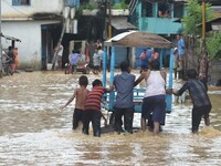 Indian man pushes a cart to ferry commuters in a flooded street after heavy downpour in Dimapur, India north eastern state of Nagaland on Th...