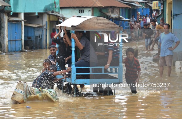 Indian man pushes a cart carrying commuters to higher ground in a flooded street after heavy downpour in Dimapur, India north eastern state...