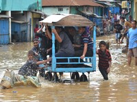 Indian man pushes a cart carrying commuters to higher ground in a flooded street after heavy downpour in Dimapur, India north eastern state...