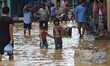 Two Indian kids wade through flooded street after heavy downpour in Dimapur, India north e...