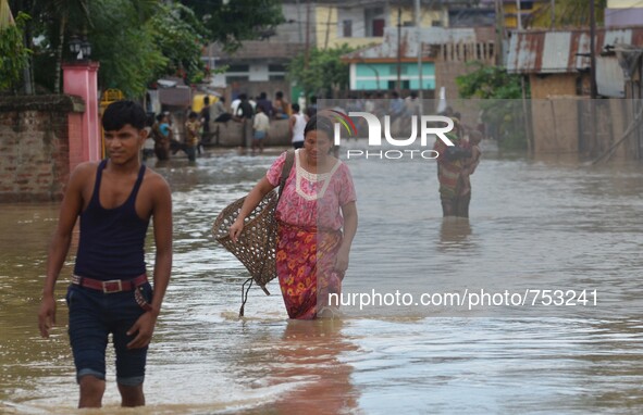 Indian residents wade through flooded street after heavy downpour in Dimapur, India north eastern state of Nagaland on Thursday, August 27,...