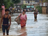 Indian residents wade through flooded street after heavy downpour in Dimapur, India north eastern state of Nagaland on Thursday, August 27,...