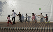 A human rights observer plays with children from the Central American migrant caravan in t...