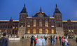 People outside of Amsterdam Centraal the main railway station of the city. Streets of Amst...