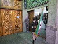 A member of the Islamic Revolutionary Guard Corps (IRGC) carrying an Iran flag past an effigy of the Iranian top IRGC commander General Qase...