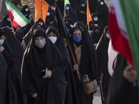 Iranian veiled women carrying Iran flags while arriving the Azadi (Freedom) sport complex to attend a death anniversary of the Iranian top I...