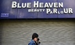 A girl walks past a closed beauty parlour as per government order amid coronavirus emergen...