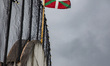 A Basque flag flyes on a grey sky in Sare, in the Basque area of the region Nouvelle-Aquit...