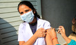 A nurse administers a booster dose of COVID-19 vaccine to a health worker in Jaipur, Rajas...