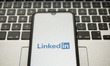 In this photo illustration a LinkedIn logo seen displayed on a smartphone screen with a co...