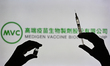 An illustrative image of a person holding a medical syringe and a Covid-19 vaccine vial in...